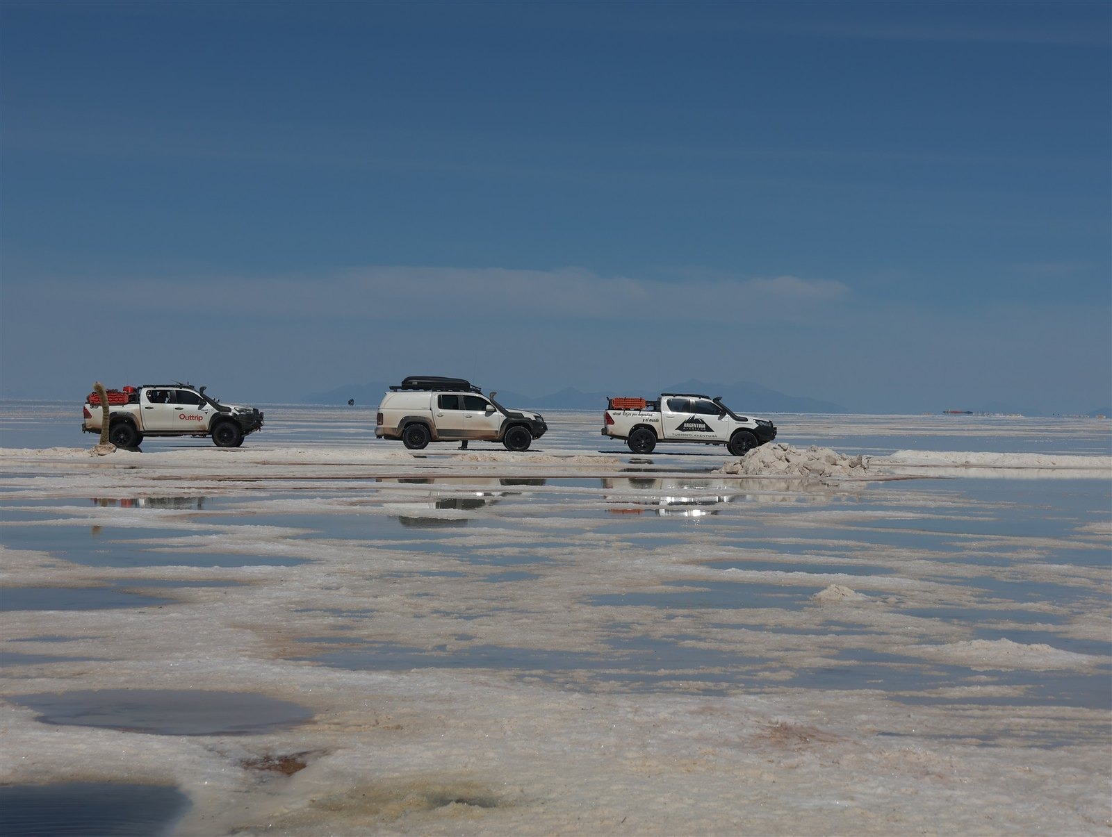 Vehículo 4x4 sobre el Salar de Uyuni al amanecer